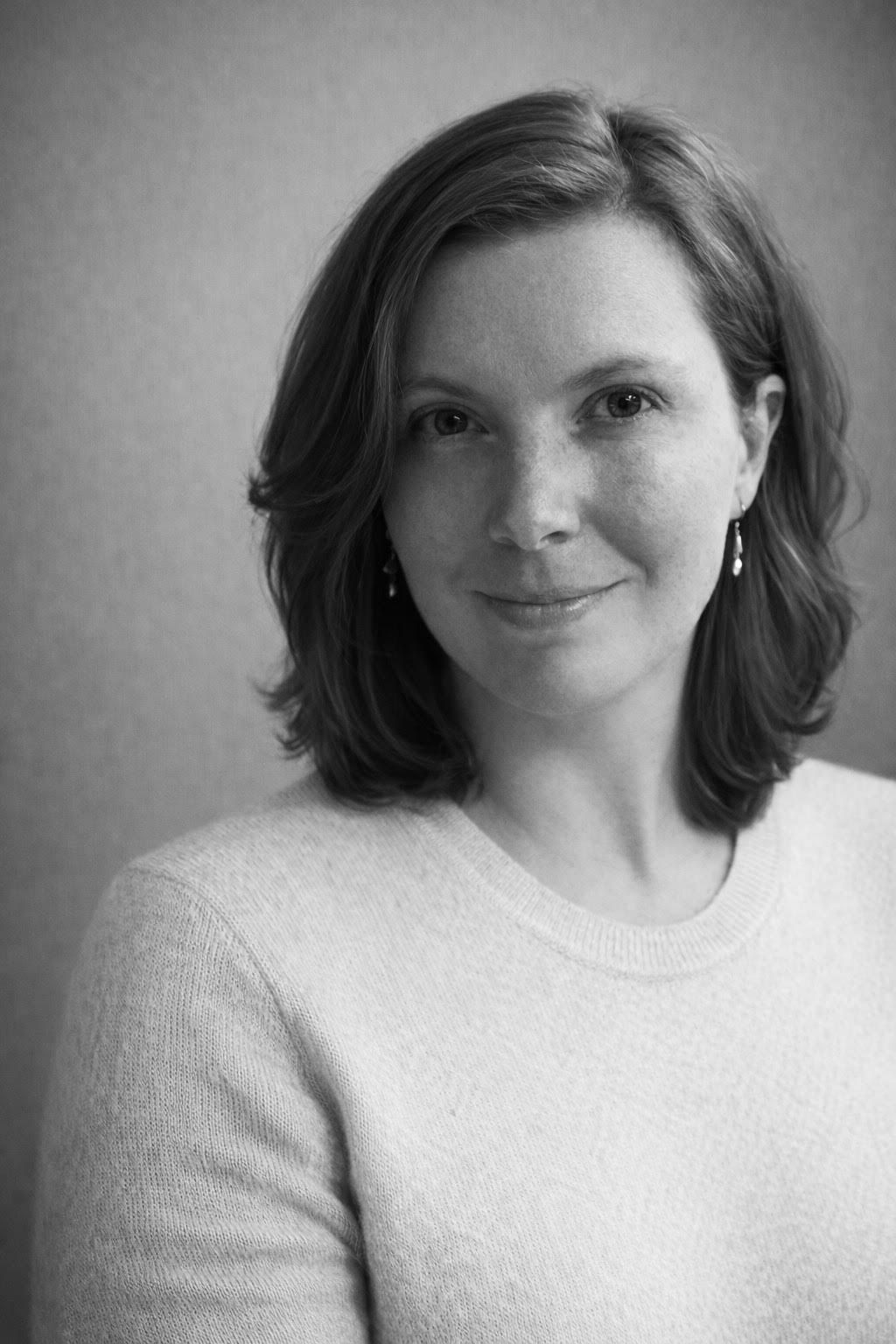 Black and white portrait of a woman with short hair wearing a light sweater.